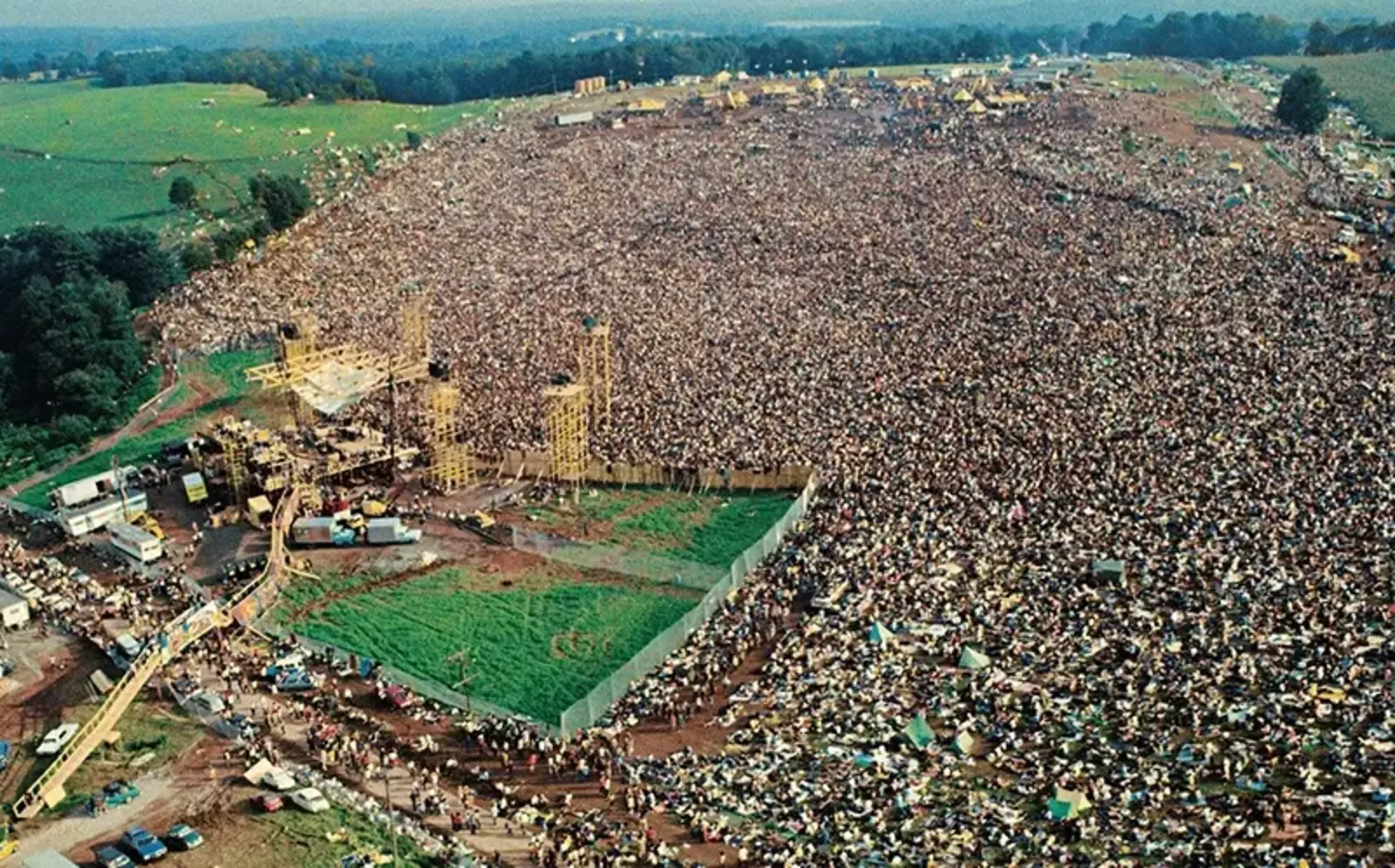 Woodstock stage and batwing fences amid the crowds / Pinterest