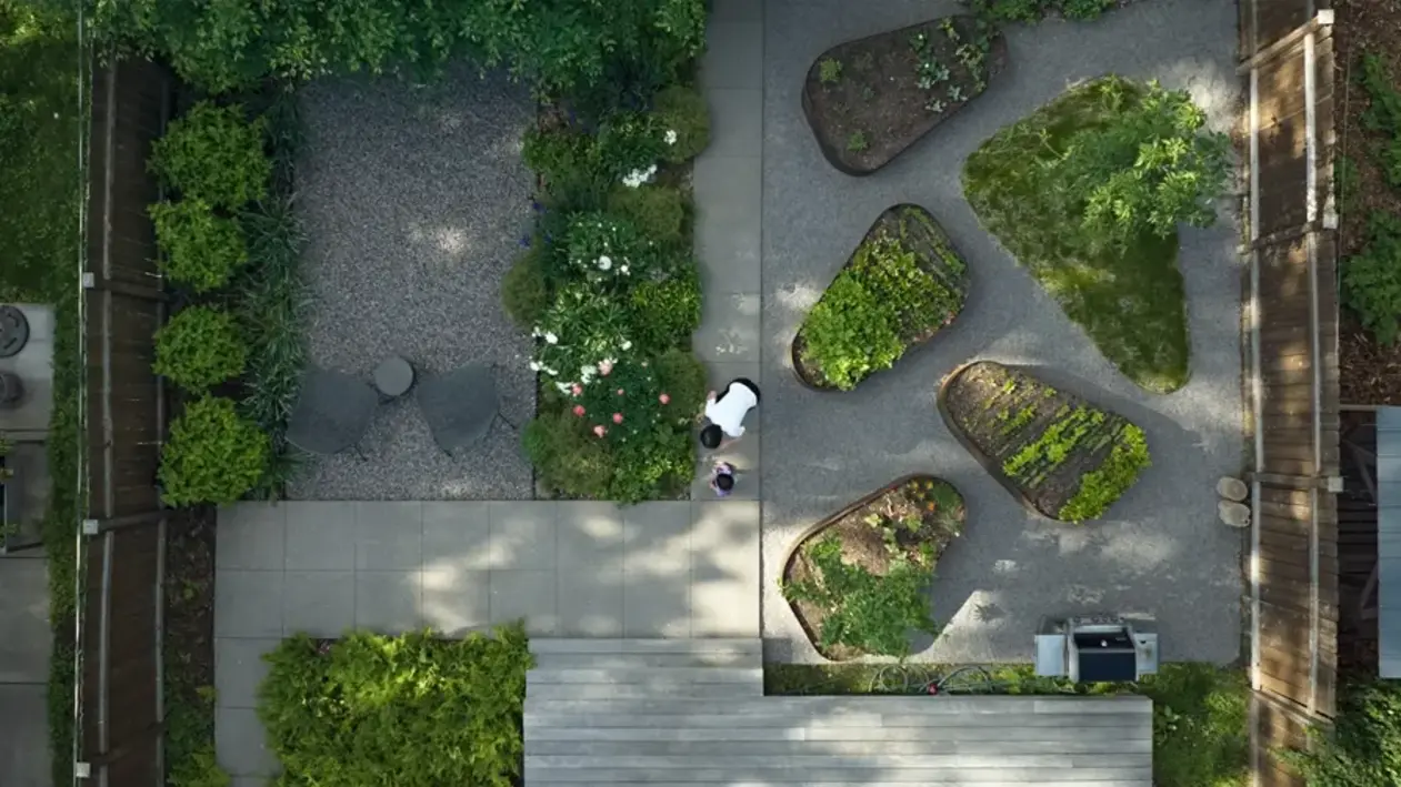 Aerial view of backyard designed as a space for family gatherings, outdoor dining, play, and shared gardening experiences
